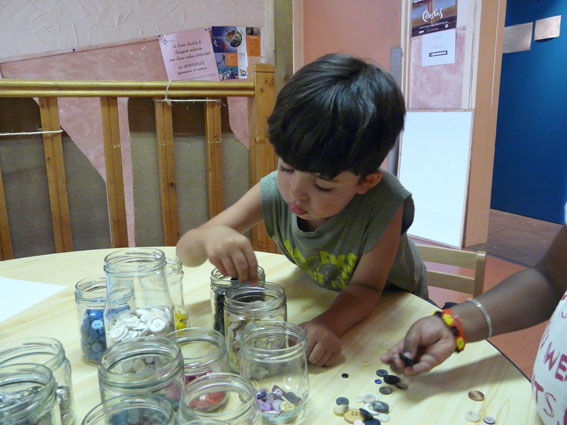 la Centrale de tri  de La Mercerie- un enfant trie les boutons par couleurs