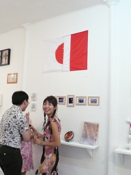 photo du public près  de l'oeuvre produite pour l'exposition Quinze ans et plus si affinités Galerie Satellite Paris 24 mai 30 juin 2007: le drapeau français boutonné au drapeau japonais
