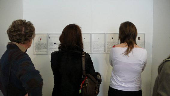 photo, une vue  du public lisant les témoignages cousus à un bouton à Thônes lors de l'exposition Acte2 Avis d'art en aravis 