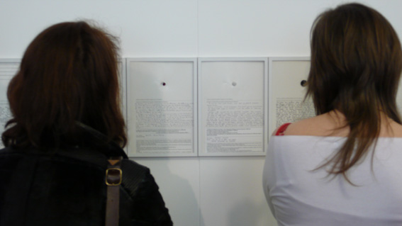 photo, une vue  du public lisant les témoignages cousus à un bouton à Thônes lors de l'exposition Acte2 Avis d'art en aravis 